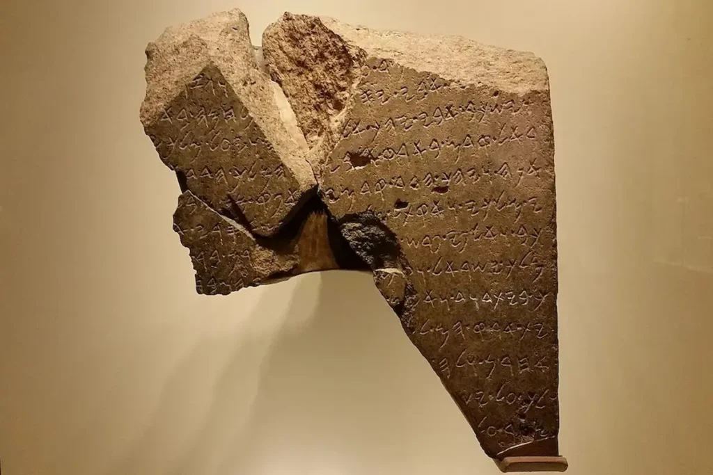 A high-resolution photograph of the authentic Tel Dan Stele, a 9th-century B.C.E. basalt stone fragment providing archaeological evidence for Bible prophecy and Israel by mentioning the "House of David."